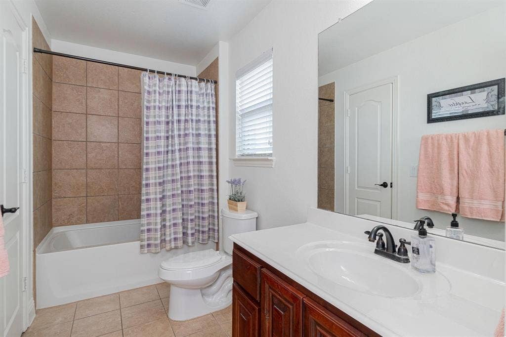 White vanity with a single basin sink and dark-finish fixtures