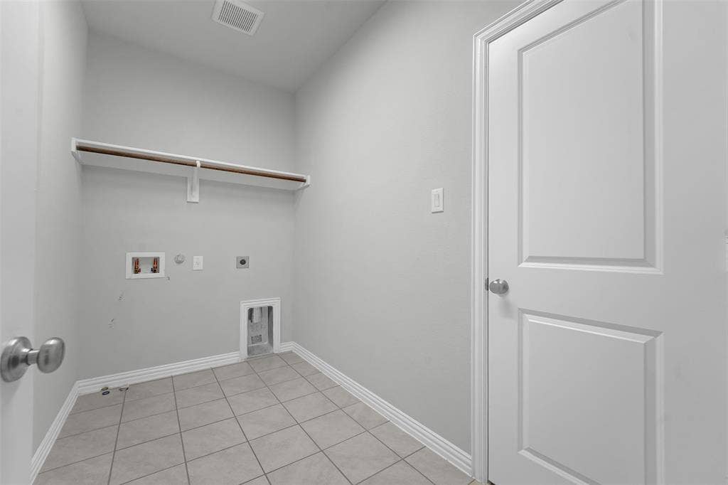 8266 Primrose Way, Dallas, TX 75252 Utility room featuring a built-in shelf with a hanging rod, tile flooring, and light gray wall paint