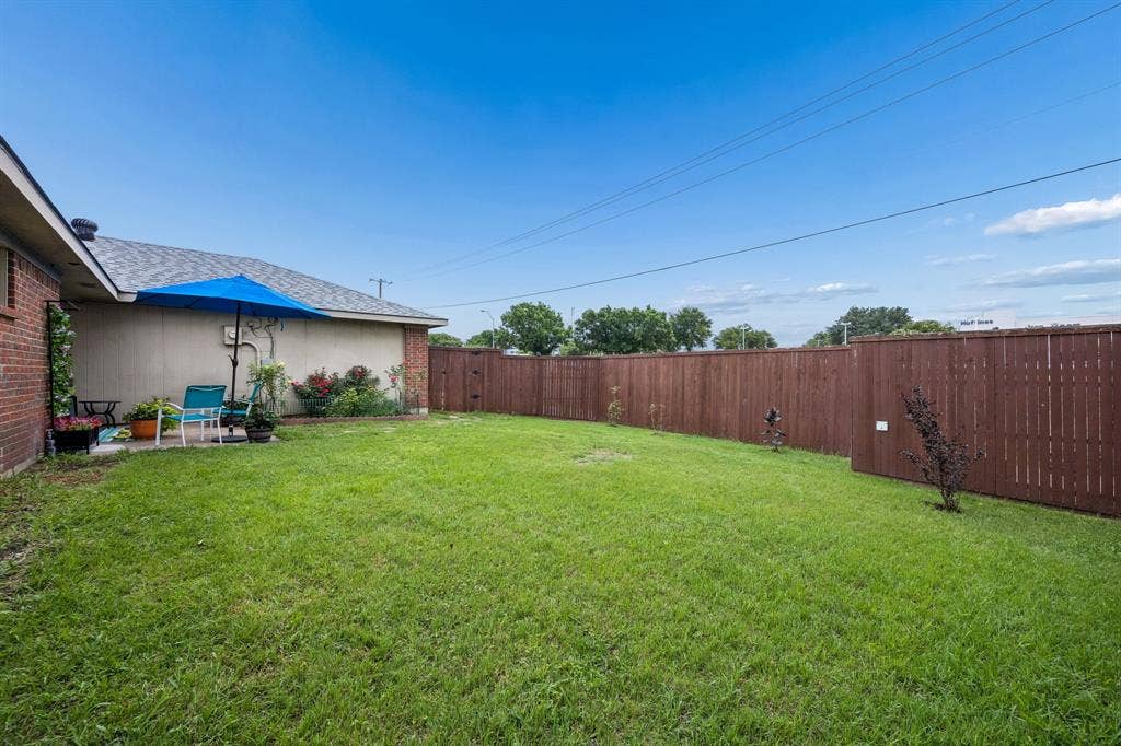 4540 New Orleans Drive, Plano, TX 75093 Expansive backyard featuring a wood privacy fence, a concrete patio, and mature landscaping