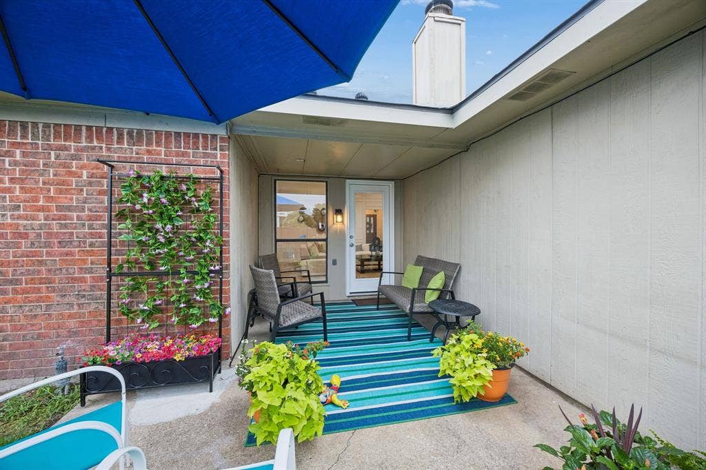 4540 New Orleans Drive, Plano, TX 75093 Covered patio with a concrete surface, brick wall, and board and batten siding