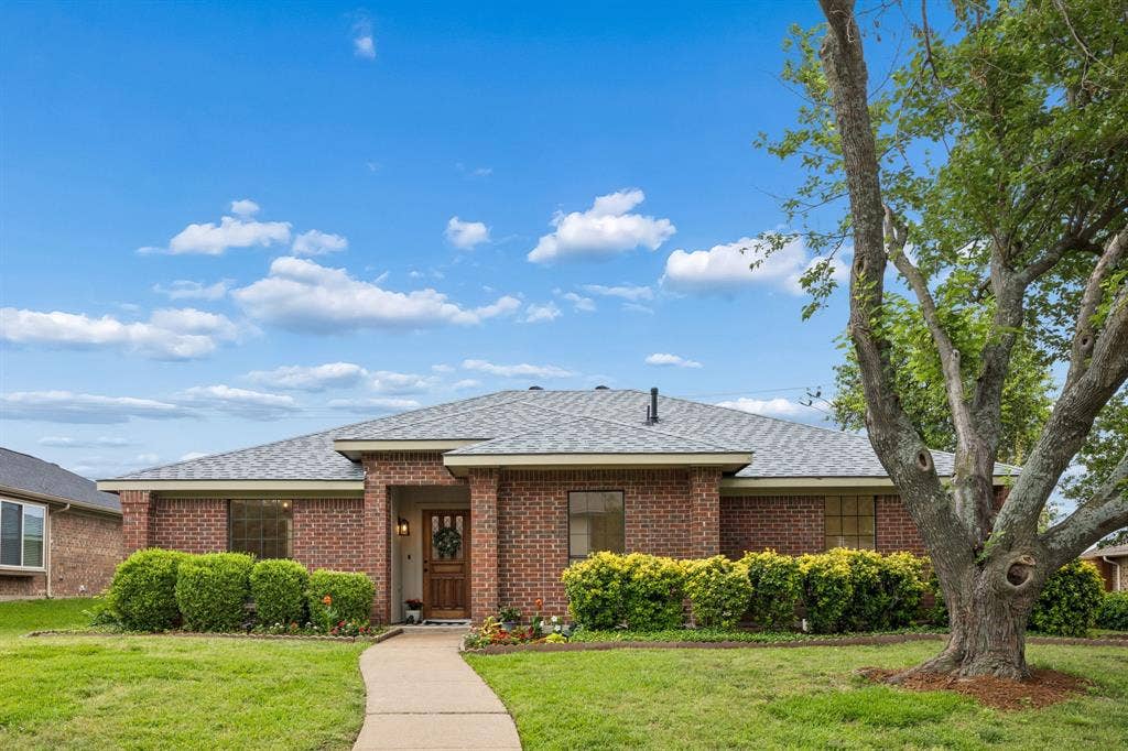 4540 New Orleans Drive, Plano, TX 75093 Brick exterior with a gray shingle roof and a wooden front door