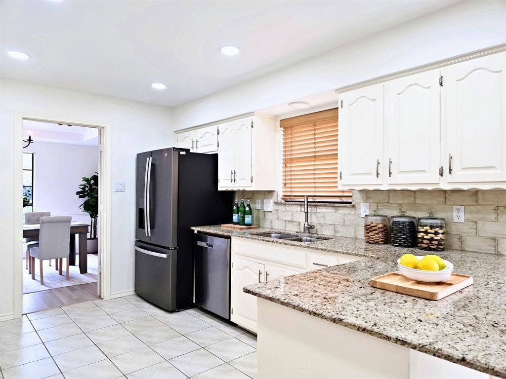 4540 New Orleans Drive, Plano, TX 75093 Kitchen featuring white shaker-style cabinetry, granite countertops, tile flooring, and a tile backsplash