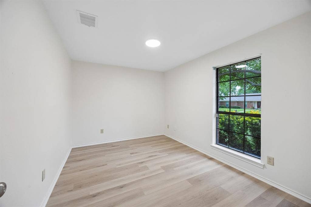 4540 New Orleans Drive, Plano, TX 75093 Neutral wall finishes, recessed ceiling lighting, wood-finish flooring, and a multi-pane window with exterior greenery
