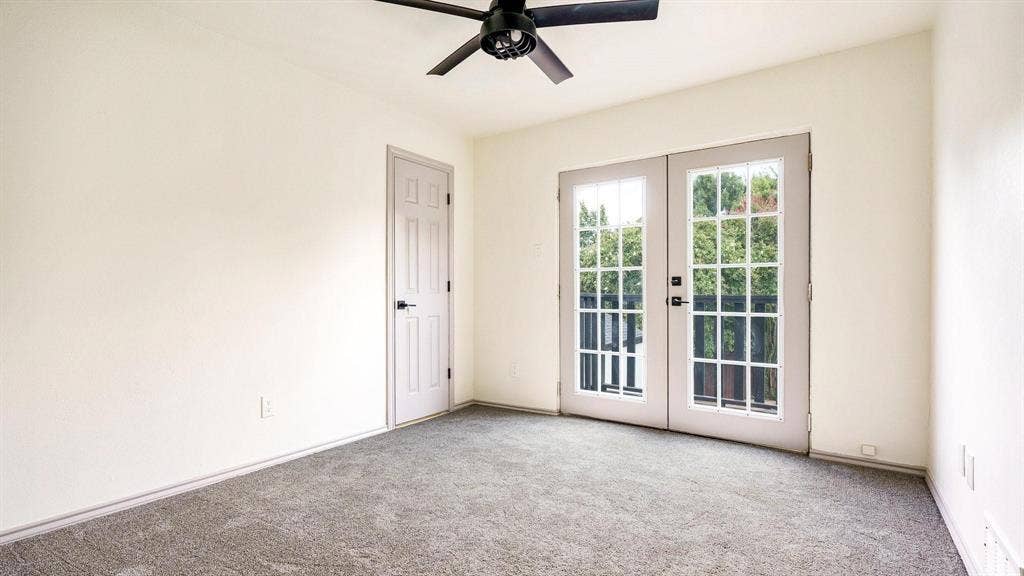 2616 Ellis Court, Plano, TX 75075 Neutral-toned wall paint, dark grey carpet flooring, black ceiling fan, white interior door with black hardware, and French doors with grid-patterned glass