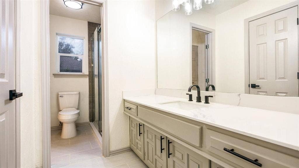 2616 Ellis Court, Plano, TX 75075 Built-in vanity with light-colored cabinetry, matte black hardware, and a single basin sink