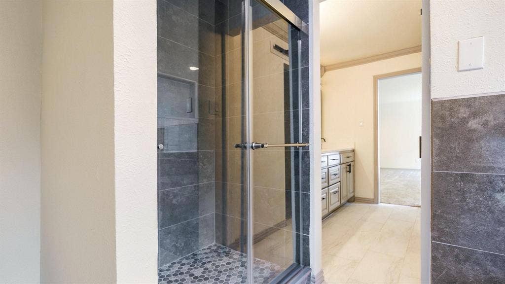 2616 Ellis Court, Plano, TX 75075 Glass-enclosed shower with gray tiled walls and a hexagonal mosaic tile floor