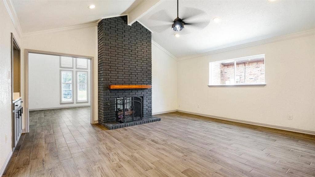 2616 Ellis Court, Plano, TX 75075 Vaulted ceiling, wood-finish flooring, black brick fireplace with wood mantel, recessed lighting, and ceiling fan