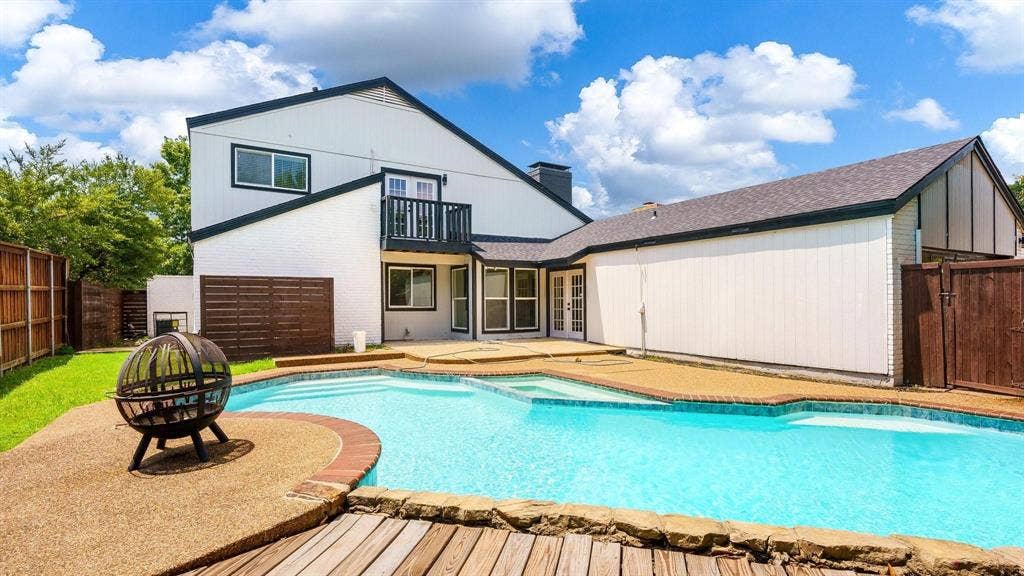 2616 Ellis Court, Plano, TX 75075 Expansive backyard with a built-in swimming pool, surrounding aggregate and wood-finish decking, and a privacy fence