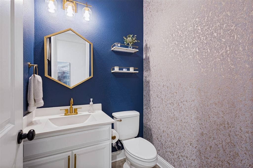 912 Lady Bird Drive, McKinney, TX 75071 Updated half bathroom located near kitchen. Fresh paint and wall paper. Updated Hardware, lighting, and mirror