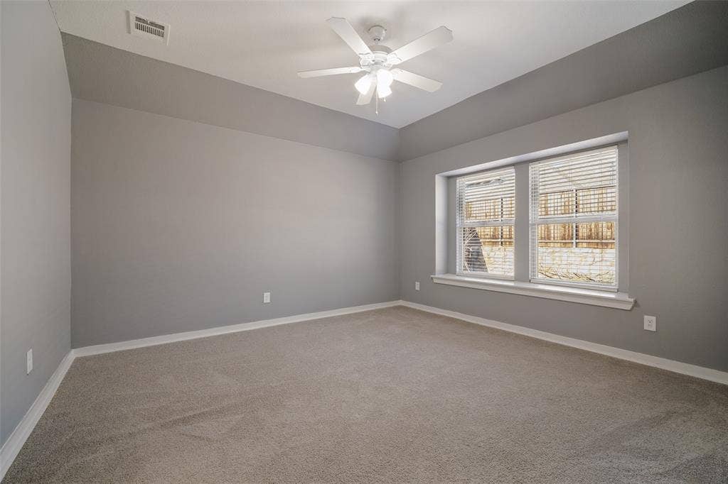 2324 Neff Lane, Forney, TX 75126 Room featuring neutral carpeting, tray ceiling, multi-blade ceiling fan with integrated lighting, and a dual-pane bay window