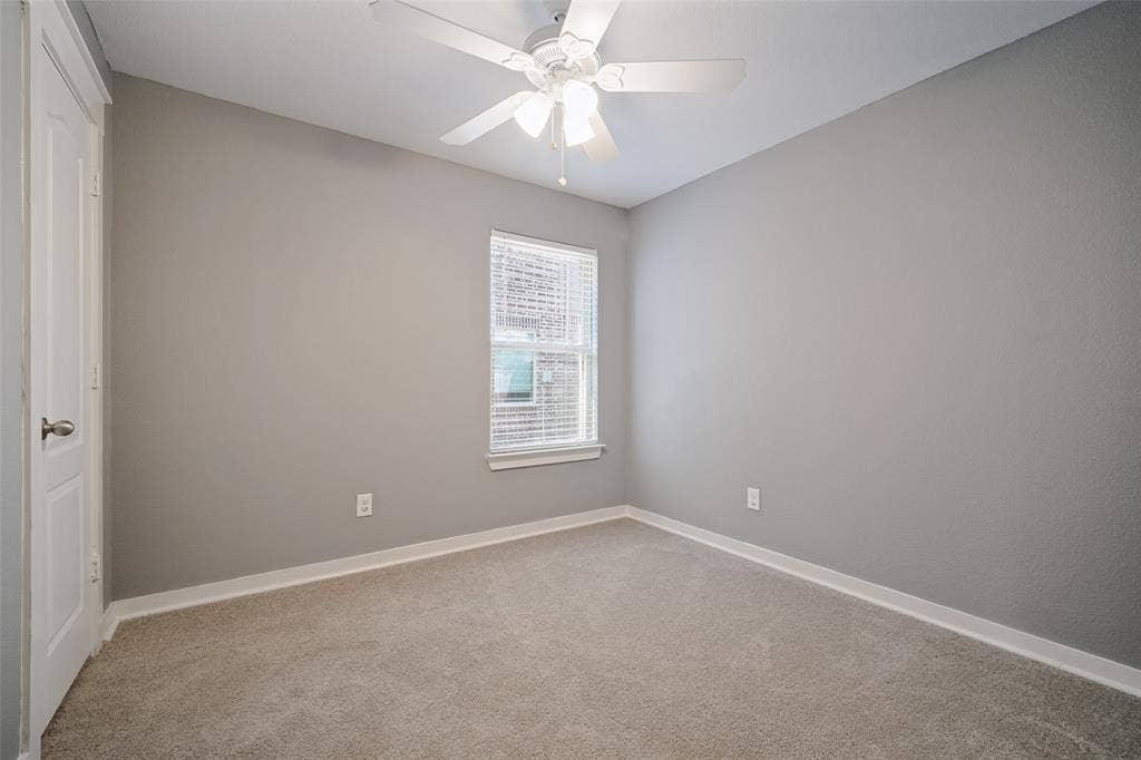 2324 Neff Lane, Forney, TX 75126 Neutral-toned interior featuring wall-to-wall carpeting, a white ceiling fan with integrated lighting, a single window with horizontal blinds, and a paneled interior door