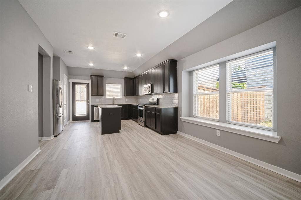 2324 Neff Lane, Forney, TX 75126 Kitchen featuring dark cabinetry, center island, light-toned wood-finish flooring, recessed lighting, and a window seat