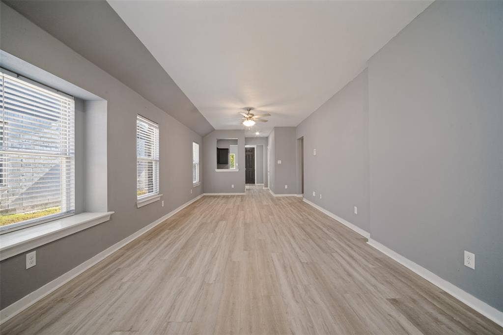2324 Neff Lane, Forney, TX 75126 Spacious interior featuring wood-finish flooring, recessed windows with built-in sills, and a centrally mounted ceiling fan with integrated lighting