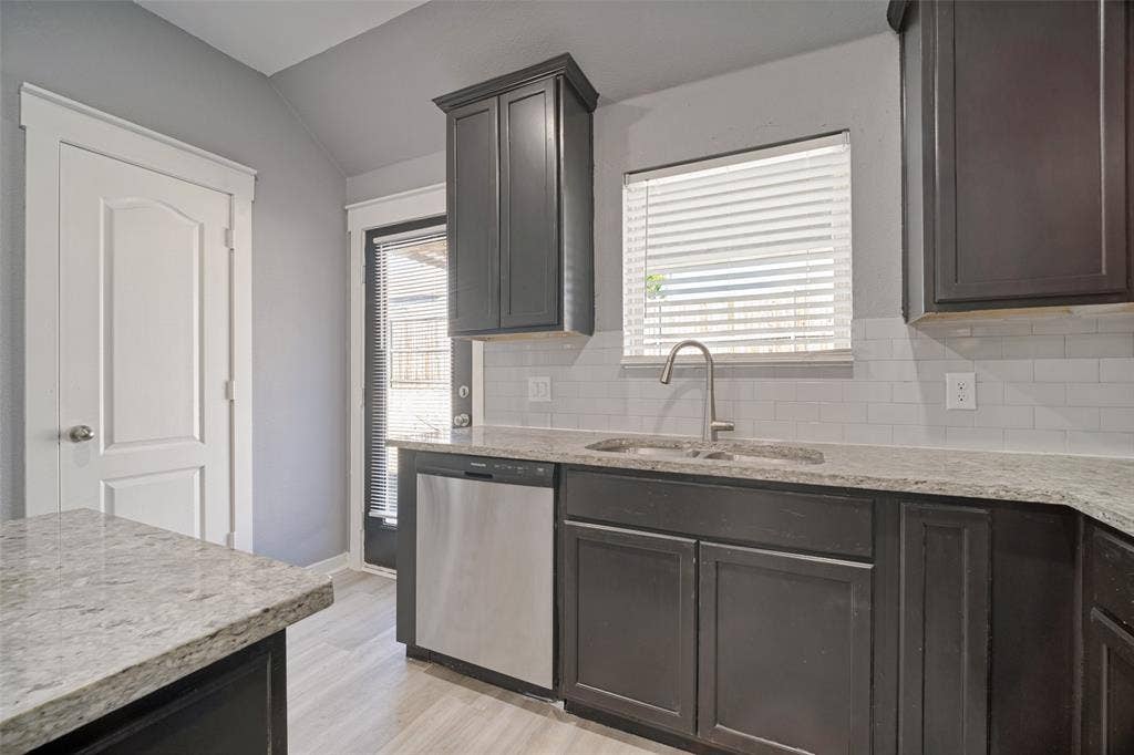 2324 Neff Lane, Forney, TX 75126 Kitchen featuring dark cabinetry, stone-finish countertops, stainless steel dishwasher, white subway tile backsplash, and a stainless steel faucet