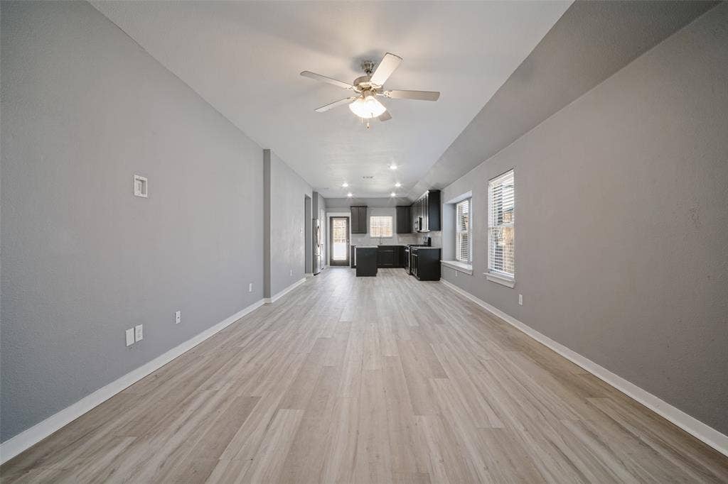 2324 Neff Lane, Forney, TX 75126 Open-concept interior featuring wood-finish flooring, vaulted ceilings with a centered ceiling fan, and recessed lighting