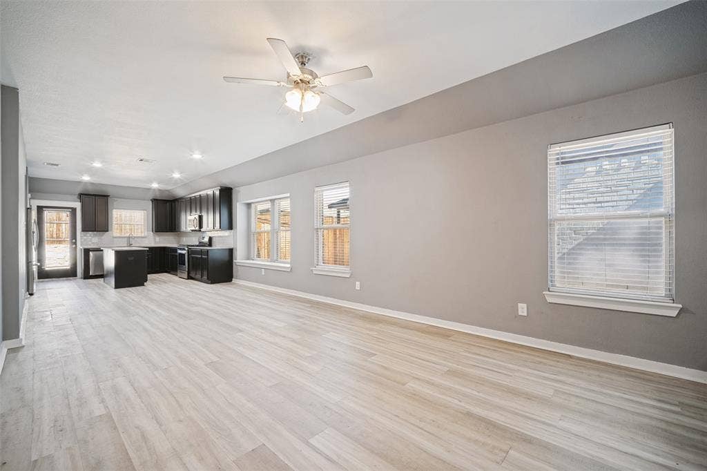 2324 Neff Lane, Forney, TX 75126 Open-concept interior featuring wood-finish flooring, dark cabinetry, a central kitchen island, recessed lighting, and a ceiling fan