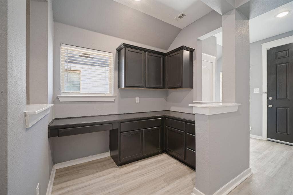 2324 Neff Lane, Forney, TX 75126 Built-in dark cabinetry with lower storage drawers, integrated desk surface, and wood-finish flooring