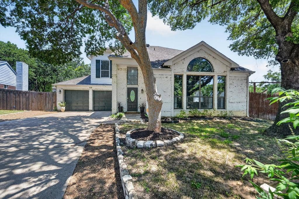519 Fox Creek Court, Denton, TX 76209 Two-story exterior with lime wash brick, arched window, and dual garage doors