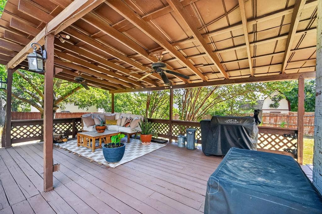 519 Fox Creek Court, Denton, TX 76209 Expansive wood-finish deck with a latticework railing, covered by a wood-beamed patio roof with ceiling fans and pendant lighting