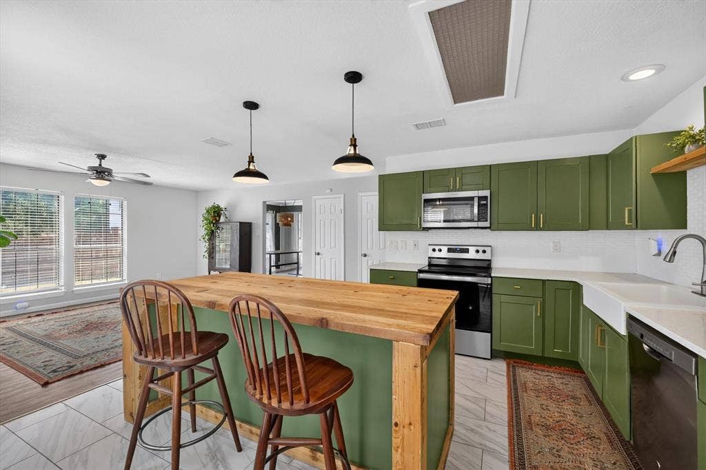 519 Fox Creek Court, Denton, TX 76209 Kitchen island with a wood-finish countertop, green base, and pendant lighting