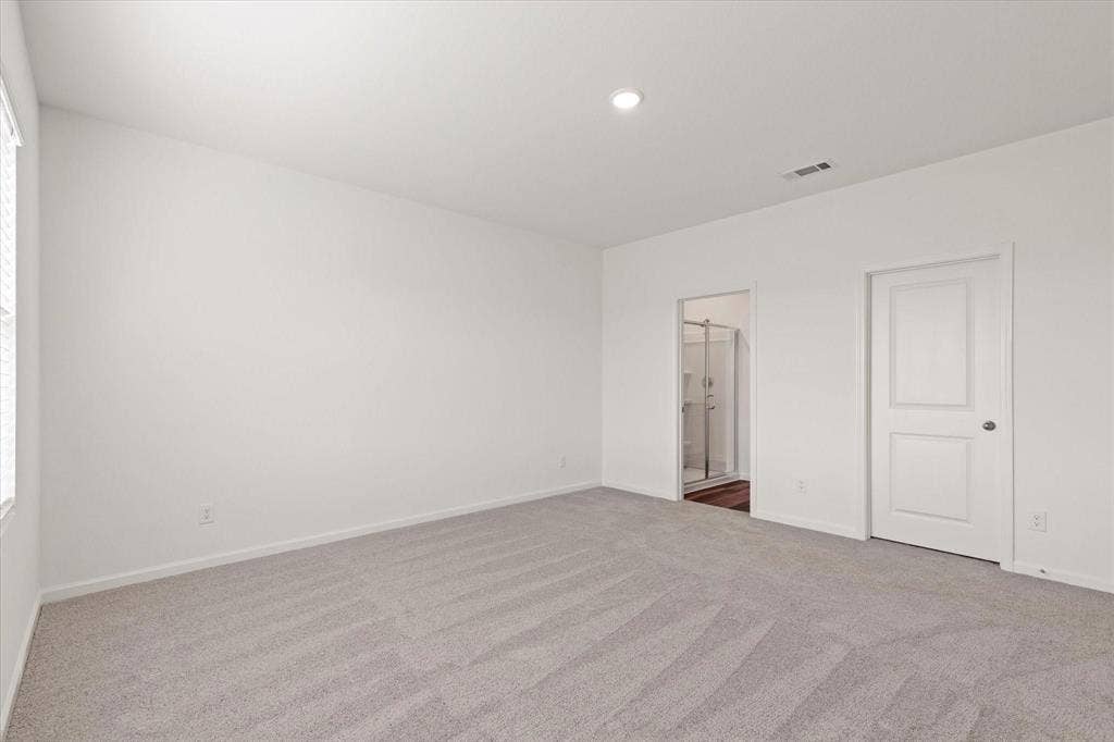 3208 Dillonwood Street, Celina, TX 75009 Recessed lighting, light gray carpet flooring, white painted walls, white two-panel interior door, and an adjacent bathroom with a glass-enclosed shower