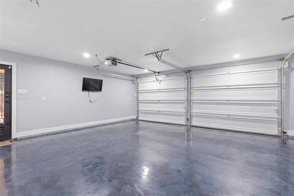 1010 Florence Drive, Duncanville, TX 75116 Two overhead garage doors, polished concrete flooring, recessed lighting, and a solid entry door with decorative glass