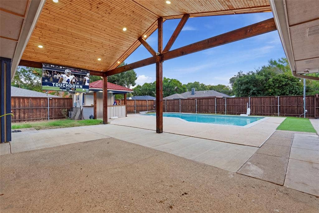 1010 Florence Drive, Duncanville, TX 75116 Expansive concrete patio with a wood-plank covered ceiling featuring recessed lighting and exposed wood beams