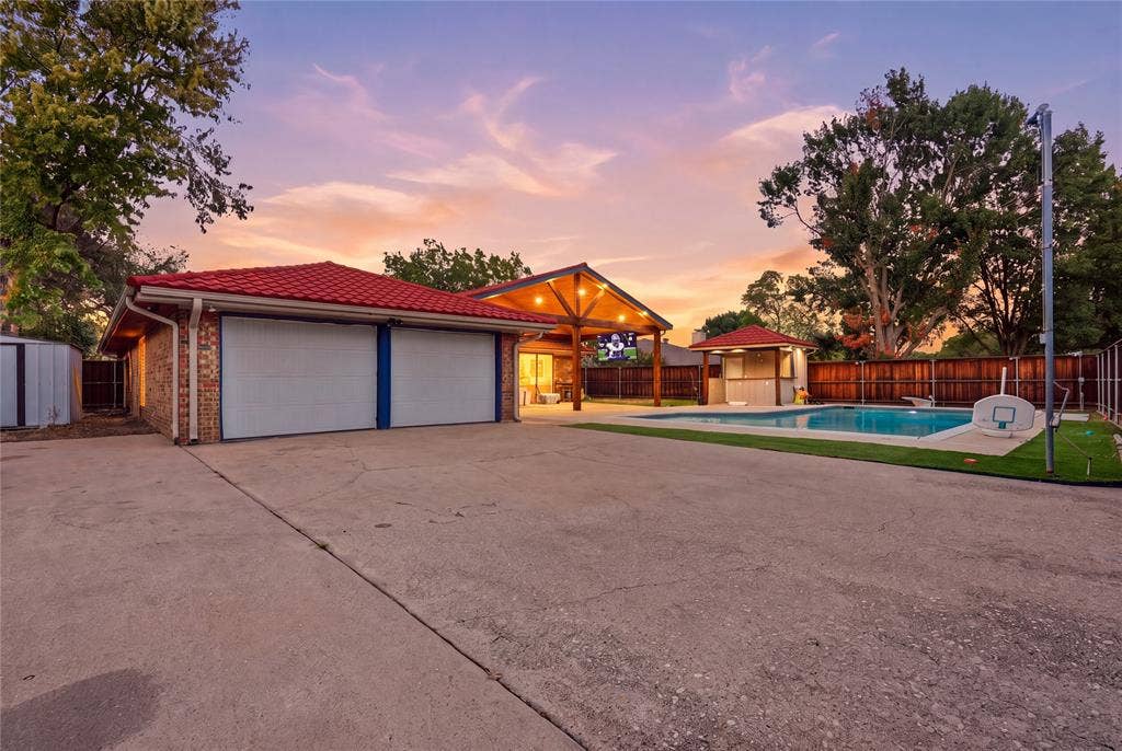 1010 Florence Drive, Duncanville, TX 75116 Two-car garage with concrete driveway, red tile roof, and brick exterior