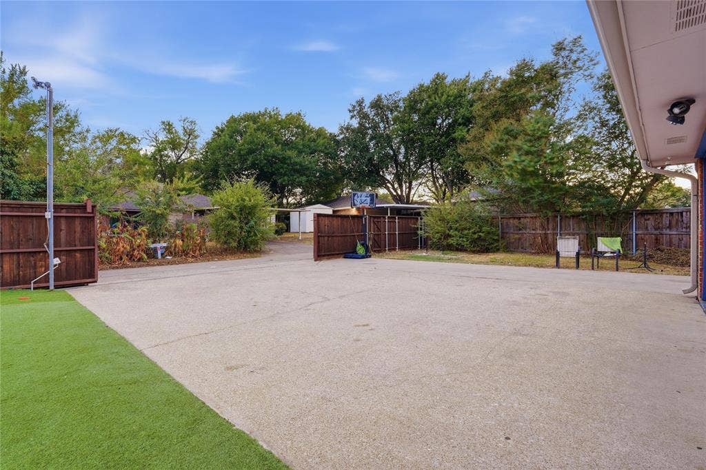 1010 Florence Drive, Duncanville, TX 75116 Expansive paved area with a wood fence perimeter