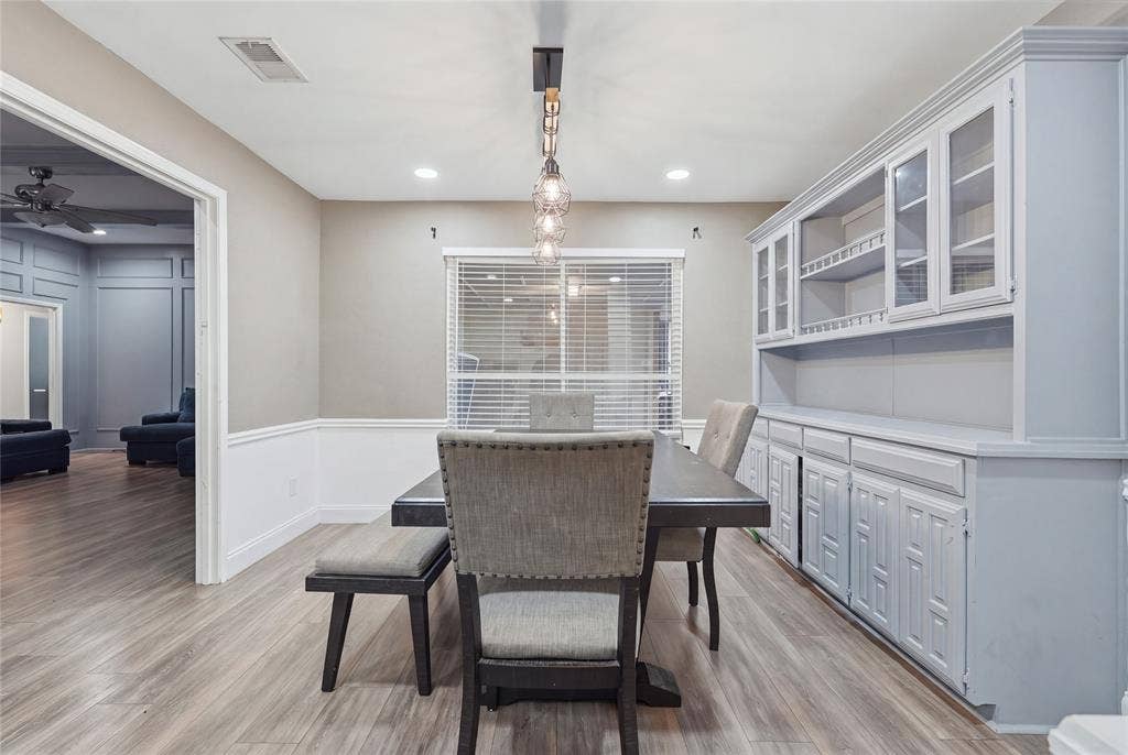 1010 Florence Drive, Duncanville, TX 75116 Wood-finish flooring, recessed lighting, and a built-in hutch with glass-front cabinetry enhance the space