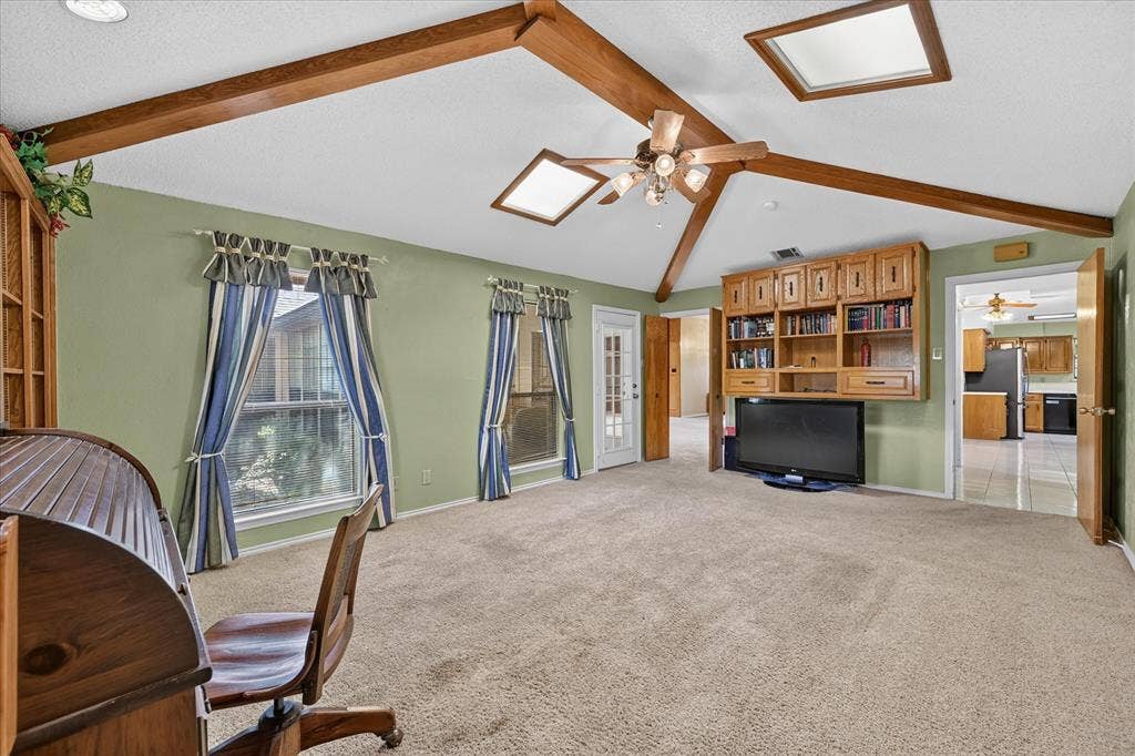 206 Harris Drive, Sunnyvale, TX 75182 Vaulted ceiling with exposed wood beams, dual skylights, and a ceiling fan