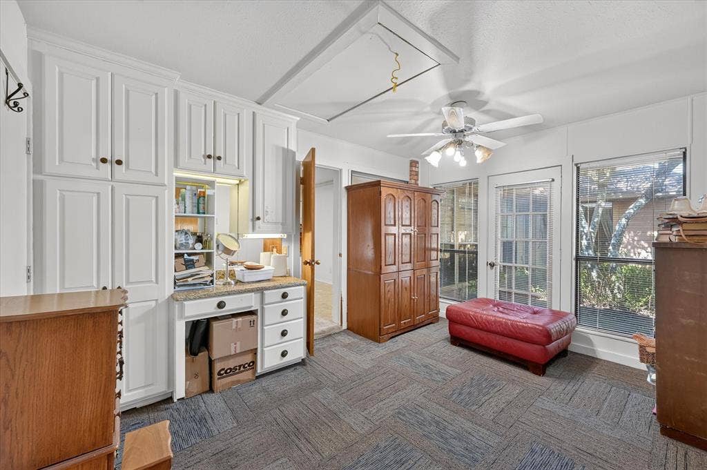 206 Harris Drive, Sunnyvale, TX 75182 Built-in white cabinetry with a vanity area, ceiling fan with light fixture, large windows, and a glass-paneled door