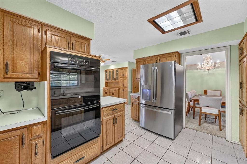 206 Harris Drive, Sunnyvale, TX 75182 Kitchen featuring wood cabinetry, stainless steel refrigerator, built-in double oven, and tiled flooring