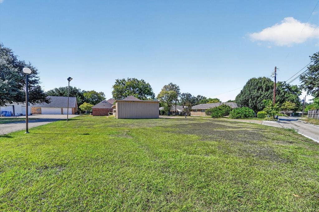 206 Harris Drive, Sunnyvale, TX 75182 Expansive green space with an asphalt path, mature trees, and a utility structure