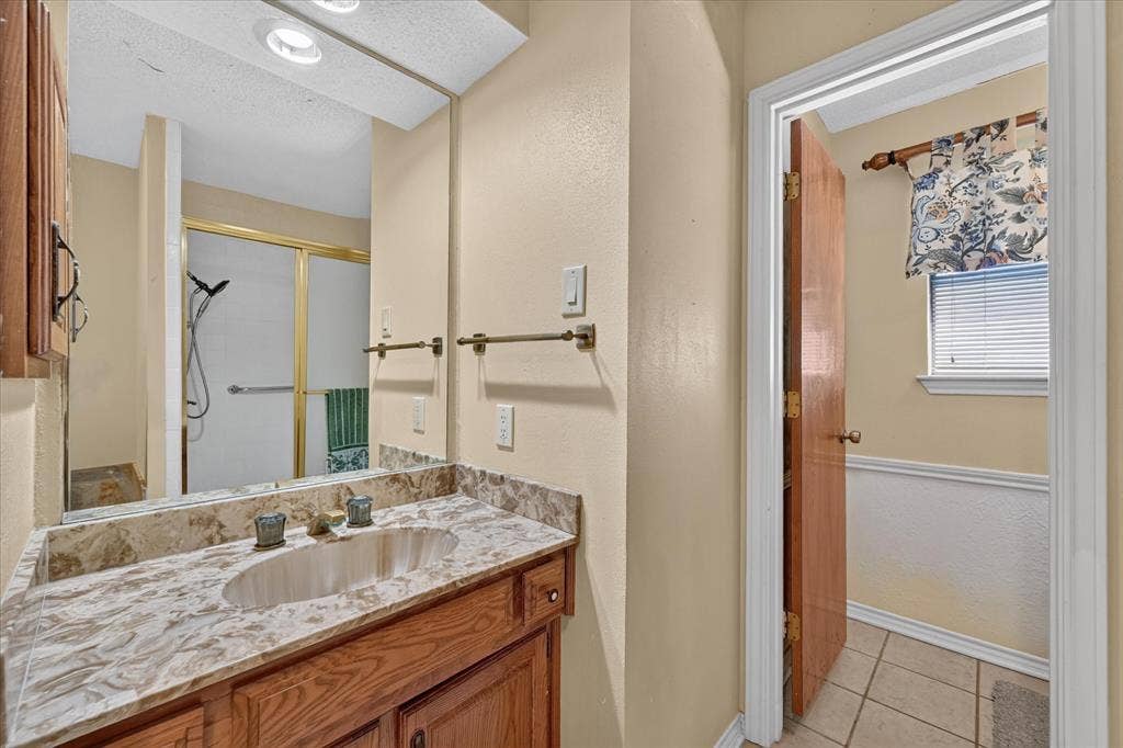 206 Harris Drive, Sunnyvale, TX 75182 Wood-finish vanity with an oval basin sink and a stone countertop