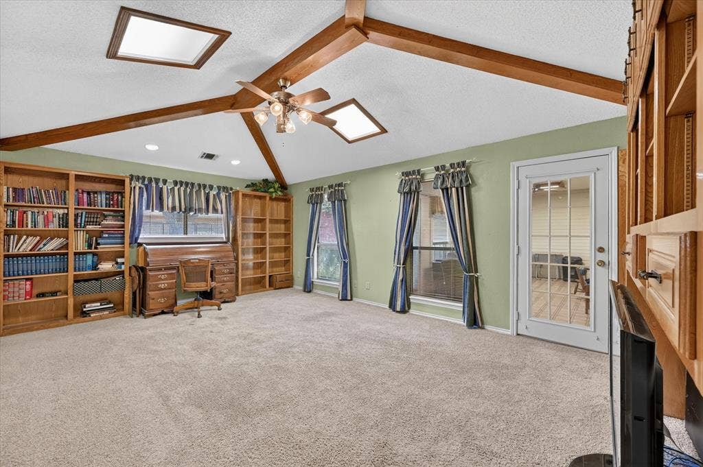 206 Harris Drive, Sunnyvale, TX 75182 Vaulted ceiling with exposed wood beams, dual skylights, and ceiling fan