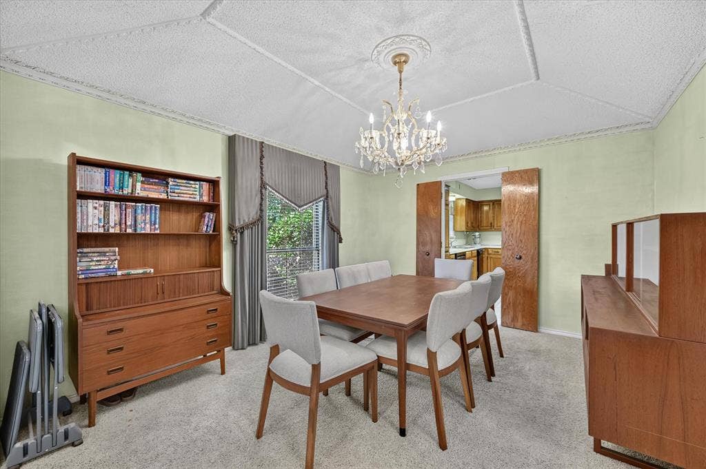 206 Harris Drive, Sunnyvale, TX 75182 Textured ceiling with decorative molding, chandelier lighting, and double bi-fold doors