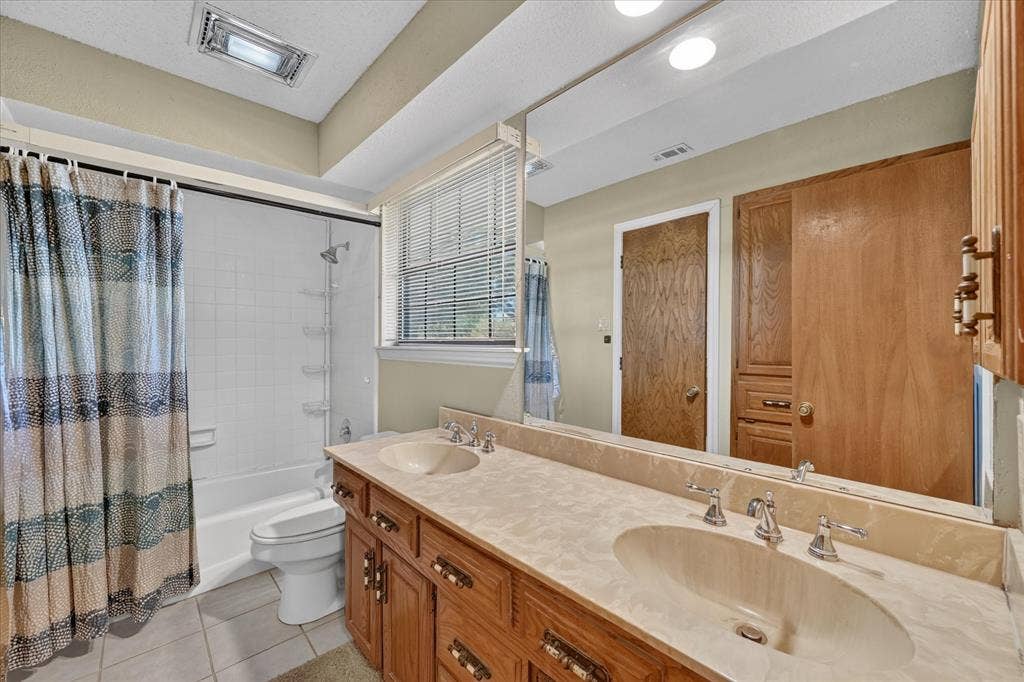 206 Harris Drive, Sunnyvale, TX 75182 Double vanity with integrated sinks, wood cabinetry, and chrome fixtures