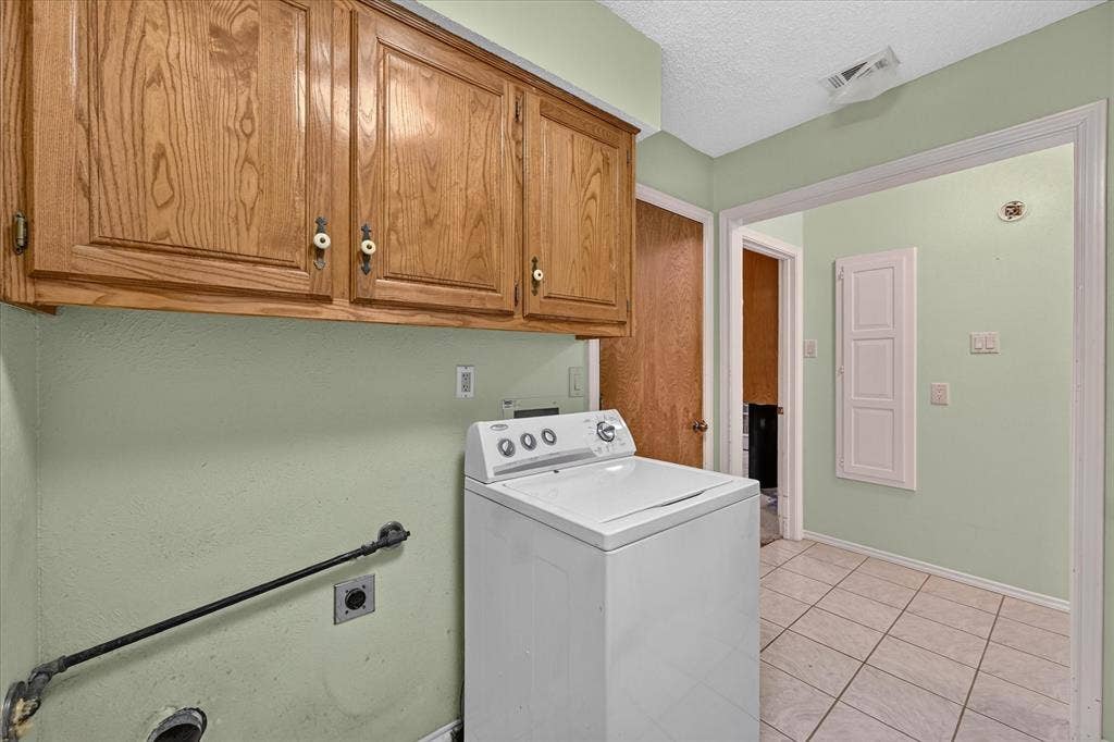206 Harris Drive, Sunnyvale, TX 75182 Built-in wood cabinetry with decorative pulls, tile flooring, and light green wall finish
