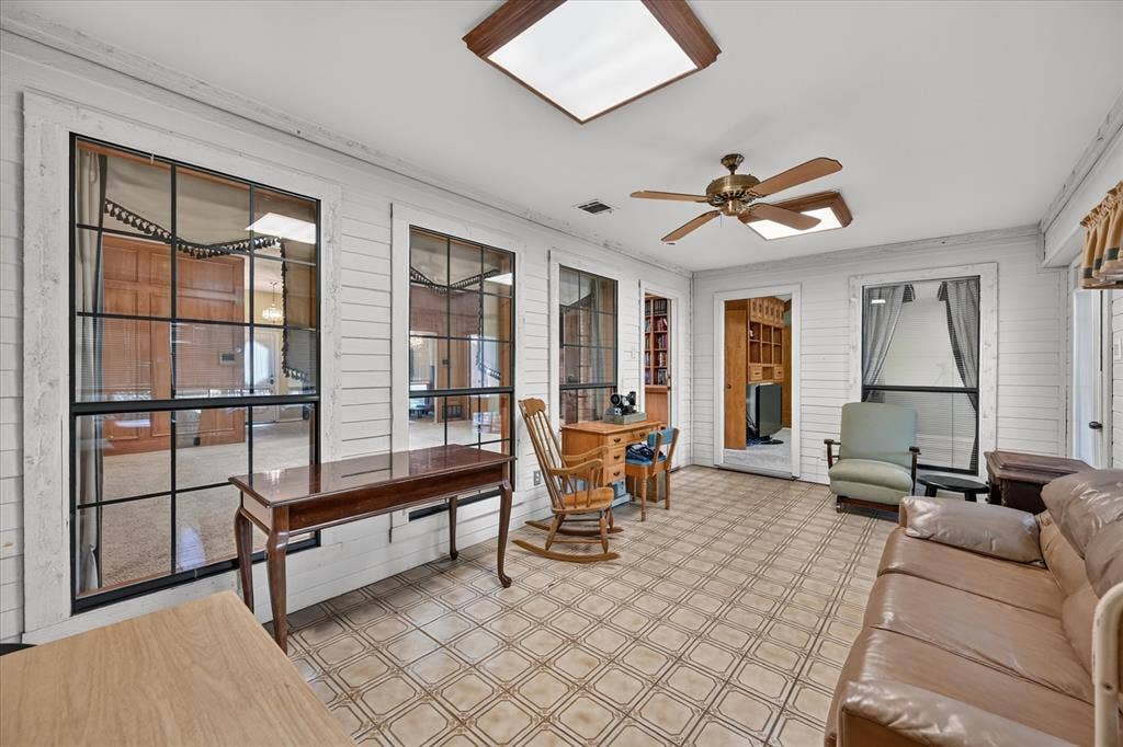 206 Harris Drive, Sunnyvale, TX 75182 Enclosed sunroom featuring multiple large windows, patterned tile flooring, and a ceiling fan with integrated lighting