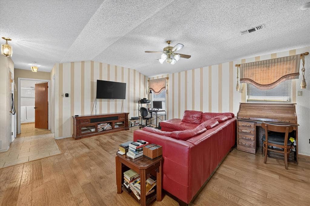 206 Harris Drive, Sunnyvale, TX 75182 Wood-finish flooring, ceiling fan, curved wall detail, recessed lighting, and a built-in media console