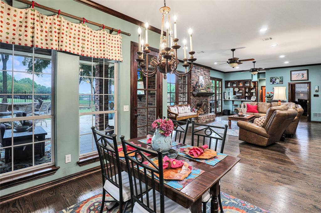 1204 Hills Creek Drive, McKinney, TX 75072 Wood-finish flooring throughout, complemented by a brick fireplace with a mantel