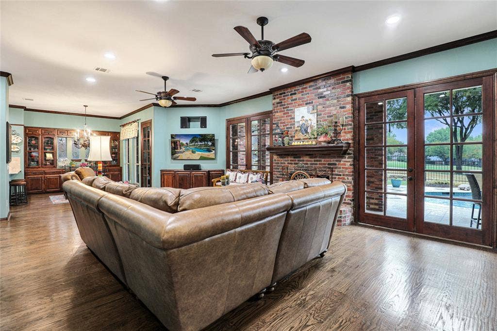 1204 Hills Creek Drive, McKinney, TX 75072 Wood-finish flooring throughout, recessed ceiling lighting, two ceiling fans, custom built-in cabinetry, and a brick fireplace