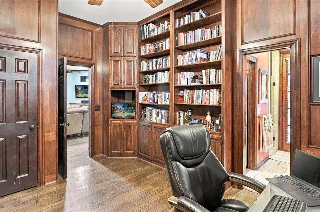 1204 Hills Creek Drive, McKinney, TX 75072 Wood-finish flooring, rich wood paneling, recessed lighting, and extensive built-in cabinetry with shelving