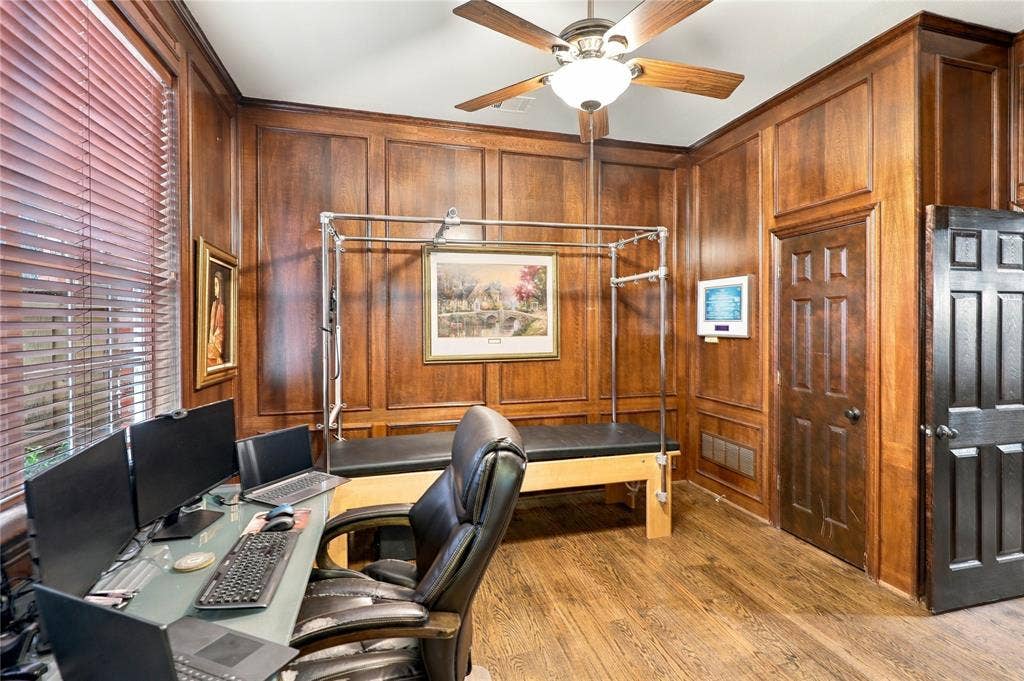 1204 Hills Creek Drive, McKinney, TX 75072 Wood-paneled walls with crown molding, wood-finish flooring, a ceiling fan with integrated lighting, and window blinds