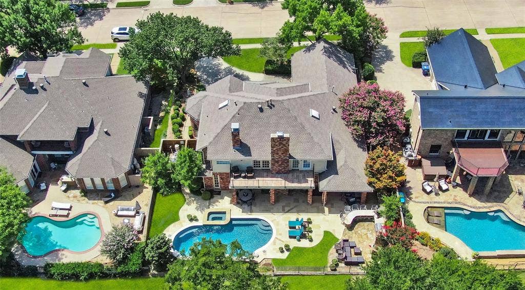1204 Hills Creek Drive, McKinney, TX 75072 Expansive backyard featuring a curved swimming pool, integrated spa, and extensive hardscaping