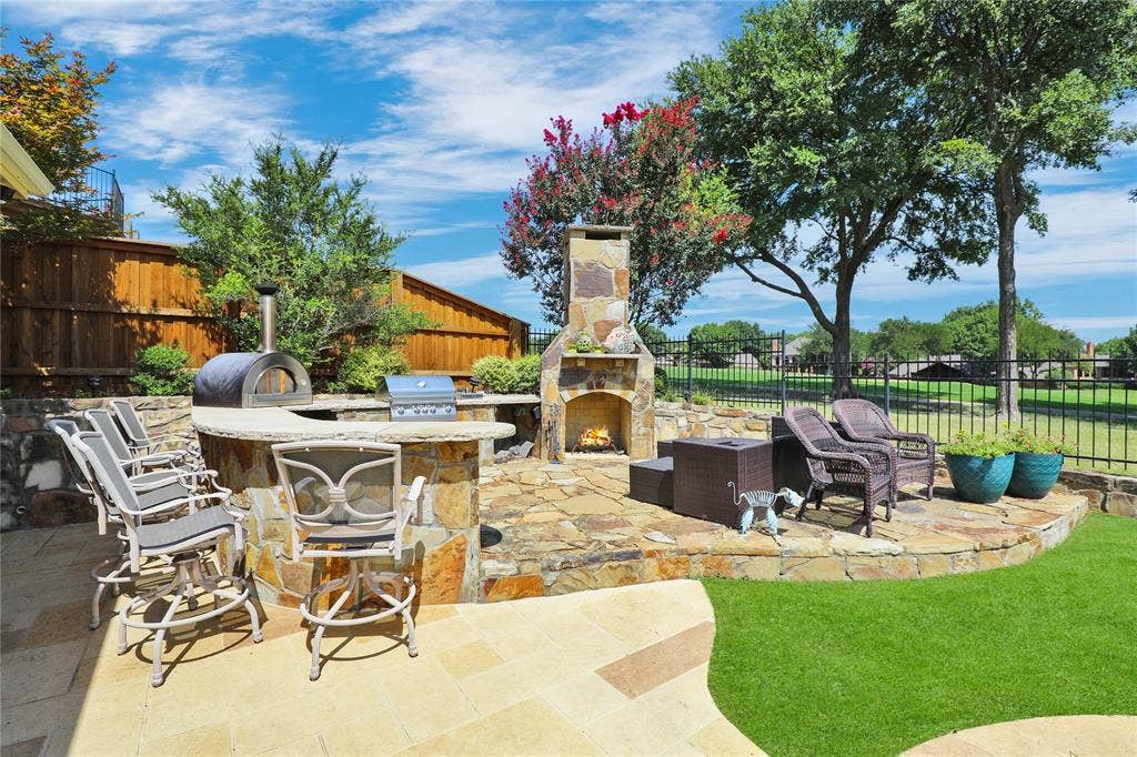 1204 Hills Creek Drive, McKinney, TX 75072 Outdoor living space featuring a stone-clad fireplace, built-in BBQ, and a pizza oven