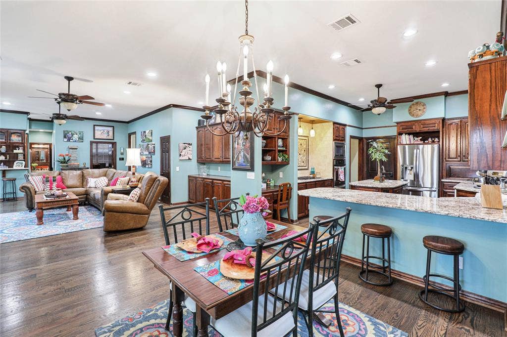 1204 Hills Creek Drive, McKinney, TX 75072 Wood-finish flooring throughout, with a formal dining area, kitchen island, and built-in stainless steel refrigerator