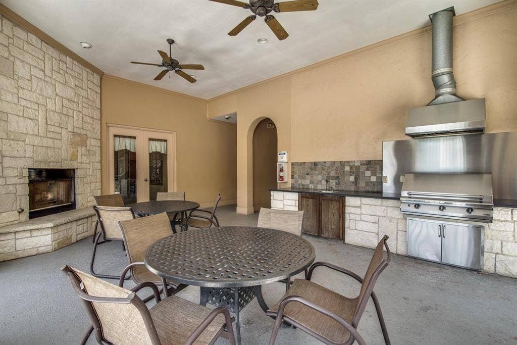 6816 Livorno Lane, Frisco, TX 75034 Outdoor living area with a stone-clad fireplace and built-in stainless steel grill