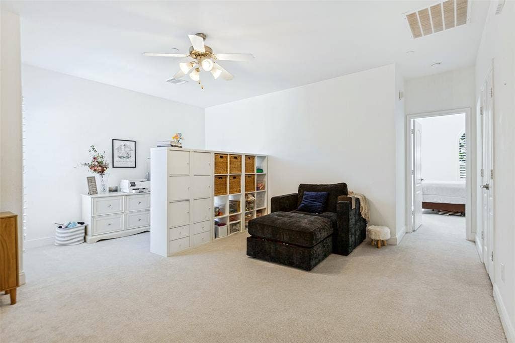 6816 Livorno Lane, Frisco, TX 75034 Expansive carpeted bonus room with future 3rd bedroom potential featuring a ceiling fan with integrated lighting, recessed lighting, and a doorway leading to an full sized laundry room.